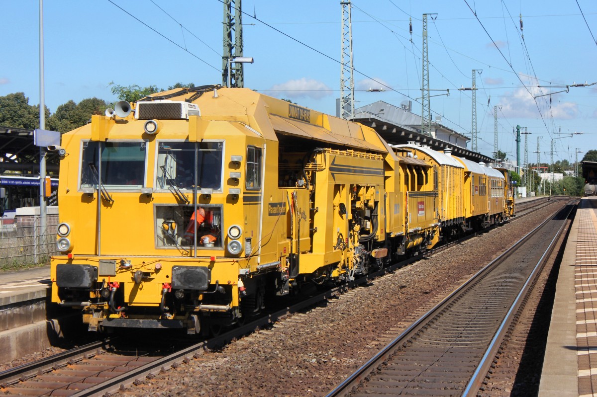 Gleisstopfmaschine und Materialwagen und Pausenwagen und Schottermaschine bei der Durchfahrt des Bahnhofs der Hansestadt Lüneburg am 27.08.2014.